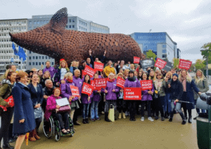 Protesters in front of pig sculpture